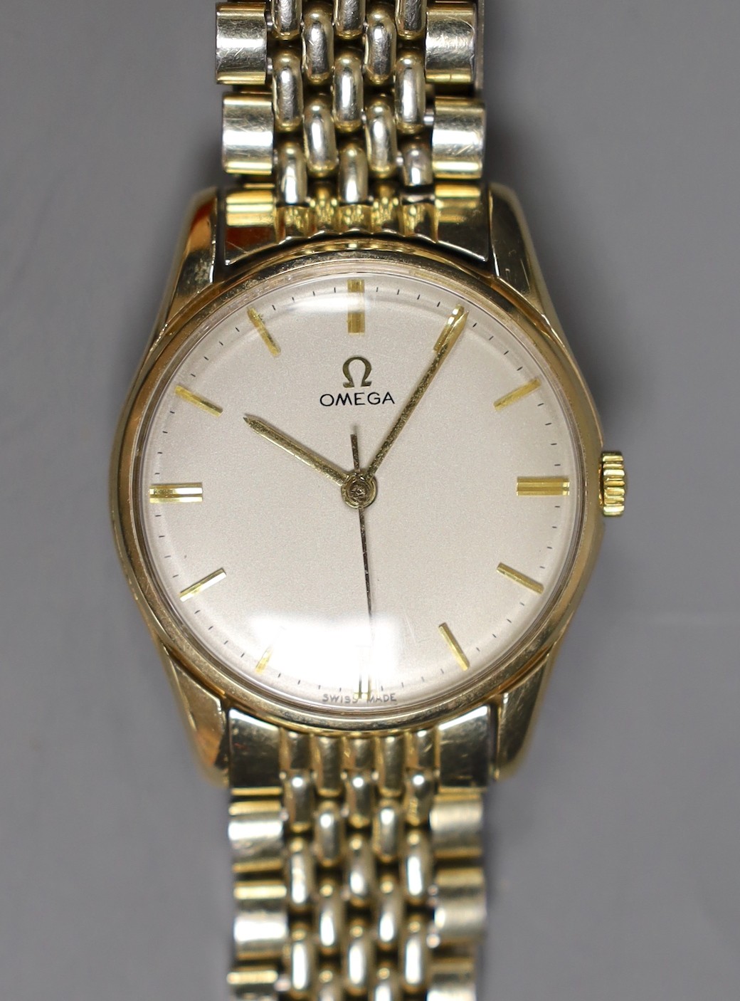 A gentleman's 9ct gold Omega manual wind wrist watch, on an Omega steel and gold plated bracelet, with box and pamphlets.